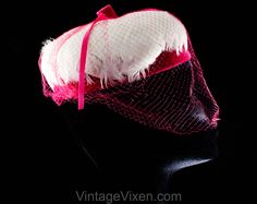 "This dome-shaped 1960s spring hat is a soft layer of thick white feathers over a base of vivid pink velvet, so charming and coy with a \"cage\" of veiling. Measurements 20 3/8 Inches Circumference at inside base of crown, approx Height 3 Inches Era 1960s Label Union label to inside back Materials White feathers, shocking pink synthetic velvet and matching diamond pattern net, matching pink stiff buckram frame Closure None needed Condition Good Condition Detail Barely worn, the netting has 6-8 s Retro Pink Brimmed Hat, Vintage Pink Costume Hats And Headpieces For Wedding, Vintage Pink Wedding Costume Hat, Pink Fitted Cap Mini Hat, Vintage Pink Fitted Fascinator, Retro Spring Mini Cap Hat, Retro Spring Fascinator Hat, Retro Spring Fascinator, Vintage Pink Mini Hat For Summer