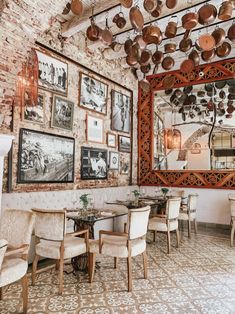 a dining room with lots of pans hanging from the ceiling and pictures on the wall