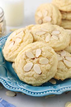 almond cookies on a blue plate next to a glass of milk