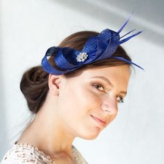 The minimalist design of this elegant bow fascinator with feathers in rich royal blue hue allows you to make it your own. You can pair it with a classic wedding dress for a timeless aesthetic or incorporate it into a more modern bridal suit or jumpsuit for a unique twist on traditional style.  Whether you're wearing your hair loose and long, in a ponytail, chignon, or half up half down style, a fascinator is the perfect finishing touch. The headpiece adds an understated feminine elegance and sop Luxury Blue Fascinator For Formal Occasions, Luxury Blue Fascinator For Royal Ascot, Luxury Blue Headpieces For Royal Ascot, Elegant Feathered Fascinator For Party, Elegant Feather Fascinator For Party, Elegant Feathered Fascinator For Formal Occasions, Elegant Mini Hats With Feathers For Gifts, Elegant Mini Hats With Feathers As Gifts, Elegant Mini Hat With Feathers For Gift