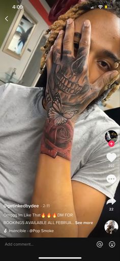 a man with tattoos on his arm covering his face