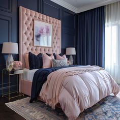 a bedroom with blue walls, pink bedding and an upholstered headboard