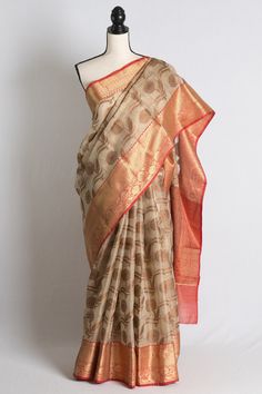 Blended Zari Kota Banarasi Saree in Beige, Red and Antique Gold. Semi, blended and art means it has synthetic fabric mixed. The fall pico is done on the saree and the blouse piece is cut and separated from the saree.   Color - Beige, Red and Antique Gold. Fabric - Blended Zari Kota. Technique - Woven. Blouse Piece - Yes (cut & separated ). Fall / Pico - Yes. Note: There may be minor variations in the shade of the product. Colors/textures show differently based on lighting, gadget settings, etc. Any displacements to stones, sequins, beads or embroidery cannot be deemed as defect in the garment/jewellery but is caused by the very nature of the work. However, missing stones or minute gaps in embroidery does not affect the overall look of the saree. Festive Chanderi Saree For Puja, Festive Chanderi Saree With Pallu Detail, Festive Chanderi Saree With Pallu, Bollywood Style Chanderi Saree With Zari Weaving, Anarkali Chanderi Saree With Pallu, Anarkali Style Chanderi Saree With Pallu, Red Cotton Silk Saree With Zari Work, Festive Slub Silk Traditional Wear With Zari Weaving, Festive Chanderi Saree With Self Design