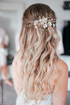 a woman with long blonde hair wearing a white dress and a flower headpiece in her hair