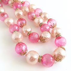 "Hot pink bubble beads and pale pink faux pearls in a double strand choker--perfect for your favorite cocktail dress or caftan! the beads are interspersed with rhinestone ring beads and goldtone filigree fittings. Super fun! 14-1/2\" long with a 3\" adjustable tail. Have even more fun with 2 pink chokers together! (Last photo shows them both) Check out my other listing: https://www.etsy.com/listing/1105538441/pink-pearl-jeweled-choker" Pink Pearl Chain Beaded Necklaces With Round Beads, Pink Pearl Chain Beaded Necklace With Round Beads, Vintage Pink Single Strand Jewelry, Pink Pearl Chain Jewelry With Round Beads, Pink Pearl Chain Necklace With Round Beads, Elegant Pink Beaded Necklaces With Round Beads, Elegant Pink Beaded Necklace With Round Beads, Feminine Pink Pearl Chain Jewelry, Pink Double Strand Beaded Jewelry