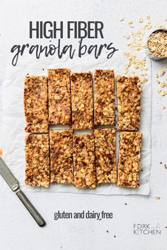 granola bars cut into squares on top of paper next to spoons and oats