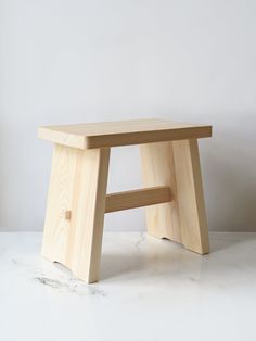 a wooden stool sitting on top of a white counter