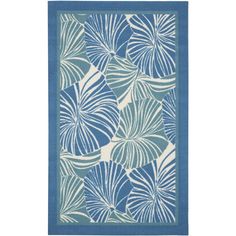 a blue and white rug with large leaves on the front, in an abstract pattern