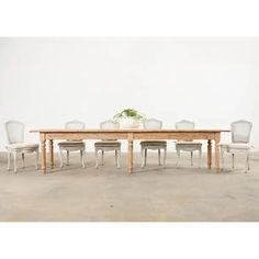 a wooden table with white chairs around it