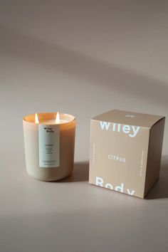 a white candle sitting next to a box