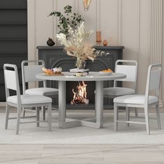 a white table with four chairs around it and a fireplace in the backround