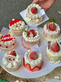 there are many different cupcakes on the plate and one is decorated with strawberries