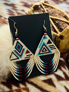 These beautiful handmade beaded hoop earrings are special , not only hand made by indigenous hands , but it's also made with colors that symbolize a heavy meaning . We call these "middle of somewhere "  , why so ? for the voyager who sets upon a destination not to think he or she is lost , but know they are always somewhere and they are always a someone . you  matter .  The color turquoise is associated with meanings of refreshing, feminine, calming, sophisticated, energy, wisdom, serenity, wholeness, creativity, emotional balance, good luck, spiritual grounding, friendship, love, joy, tranquility, patience, intuition, and loyalty.  The color maroon stands for passion and intensity , sophistication... wisdom and last but not least ... compassion .  The color of cream sits as a form of puri Spiritual Grounding, Beaded Fringe Earrings, Friendship Love, Indigenous Culture, Bead Work Jewelry, He Or She, Handmade Beaded Jewelry, Color Turquoise, Work Jewelry