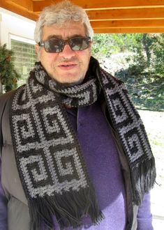 a man wearing sunglasses and a knitted scarf