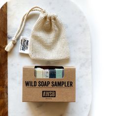 three soap bars sitting on top of a white marble counter next to a drawstring bag