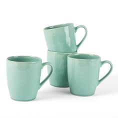 four green coffee mugs sitting next to each other on a white surface with one cup in the middle