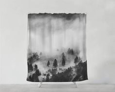 a black and white shower curtain with trees in the woods on it's side