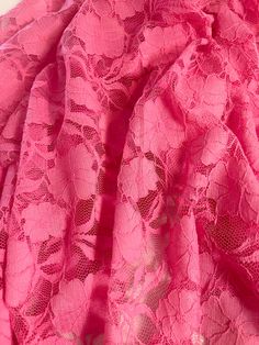 a pink dress with lacy lace on the bottom and neckline is shown in close up