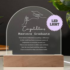 an award plaque with the words congratulations masters graduate in white ink on a wooden base