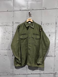 70's OG-107 Fatigue Button Up Shirt- Vietnam War(Army Green)  Great vintage condition. See pictures for condition 16.5x34 . Please review measurements as some vintage items fit smaller than modern sizing. Measurements taken with garment laid flat: 23.5" across from armpit to armpit 30" length from shoulder to hem 25" sleeve from shoulder to hem Please send a message if you have any questions. Double check measurements and inspect all pictures carefully before purchasing. Orders ship via USPS. Al Vintage Khaki Button-up Shirt, Vintage Green Shirt With Button Closure, Vintage Green Button-up Shirt, Vintage Green Buttoned Shirt, Vintage Long Sleeve Shirt With Button Closure, Vintage Khaki Shirt With Button Closure, Vintage Collared Khaki Shirt, Vintage Khaki Button-up Top, Vintage Cotton Shirt With Snap Buttons