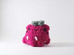 a small crocheted elephant with a gray hat on its head and eyes, sitting in front of a white background