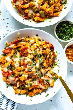 two white bowls filled with pasta and vegetables