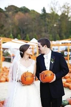 a bride and groom holding pumpkins in their hands