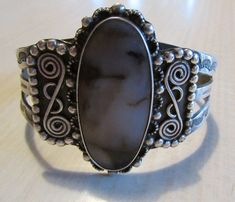 "Large sterling silver cuff bracelet with agate stone. Fred Harvey Era. Oval stone with ornate silver work. The bracelet is a wide split band with very nice stamp work. Good vintage condition with natural patina. The top is 2 7/8\" tall x 2 7/8\" wide. The inside measures 6 7/8\" including a 1 1/4\" opening. Lots of silver balls and scroll work in the design. Beautiful bracelet. Shipped by insured US first class mail. SBT-2" Vintage Agate Bracelet Jewelry, Silver Untreated Cuff Bracelet Gift, Bohemian Silver Oval Cuff Bracelet, Vintage Agate Bracelet, Unique Silver Agate Cuff Bracelet, Silver Cuff Bracelet With Cabochon, Unique Silver Cuff Bracelet With Cabochon, Silver Agate Bangle Cuff Bracelet, Vintage Silver Cabochon Cuff Bracelet