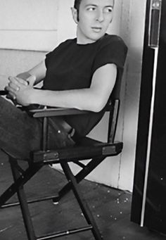 a young man sitting in a folding chair