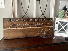 a wooden sign that says our favorite people call us grandma and papa on it next to a candle holder