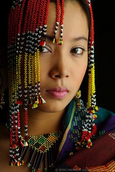 a woman wearing beaded headdress and necklaces