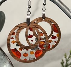 two wooden earrings with autumn leaves on them