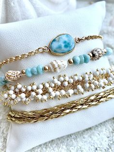 "Beautiful Ocean Lover Bracelet Set Including Larimar Ocean Goddess Chain Bracelet Larimar & Bahama sea shell Bracelet White Coral Bracelet Golden double leather wrap All bracelets are 14k gold over sterling silver 100 % ocean proof Floridian Ocean Jewelry \"Sea Lifes Beauty\"" Ocean-inspired Yellow Gold Beach Jewelry, Elegant Stackable Beach Jewelry, Ocean-inspired Gold Bracelets For Gifts, Ocean-inspired Gold Bracelets For Gift, Ocean-inspired Gold Bracelet For Gift, Gold Stackable Beach Jewelry, Beach Gold Hand Wrapped Jewelry, Gold Stackable Jewelry For Beach, Gold Stackable Jewelry For The Beach