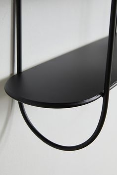 a black shelf is hanging on the wall