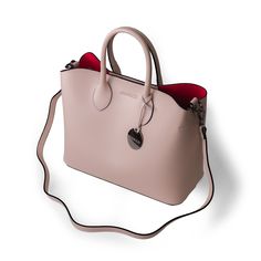 The Jessica Mae tote bag( named after an Endrizzi Founder) is part of our core line of products. It's a minimalist, chic and trendy, tote-style handbag that is built for power females. It features a contrasting red interior which makes this nude tote bag stand out from the crowd. The Jessica Mae is both trendy and classic - an easy choice for everyday use and a busy lifestyle. Safety Safety is also top of mind in this tote bag. The main compartment is closed by a double set of magnetic locks, wh Nude Tote Bag, Nude Handbag, Bag Names, Busy Lifestyle, Minimalist Chic, Bag Stand, Red Interior, Coach Horse And Carriage Tote, Have Metal