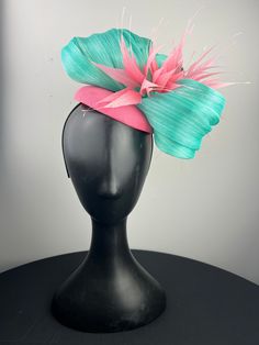 A candy pink button base topped with elegant aqua abaca silk with a pink feather crowns. Sits on a comfortable black headband. Ships in a high quality storage box. One of a kind.  Perfect for Kentucky Derby, Royal Ascot, church, weddings, just for fun. Fitted Pink Mini Hat With Feather Trim, Pink Ostrich Feather Fascinator, Adjustable Pink Mini Hat With Feathers, Pink Feather Trim Headpiece For Kentucky Derby, Adjustable Pink Feather Fascinator, Adjustable Pink Fascinator With Feathers, Pink Adjustable Fascinator With Feathers, Adjustable Pink Feathered Fascinator, Adjustable Pink Feather Trim Headpieces