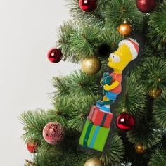 a christmas ornament hanging from the side of a tree with ornaments around it