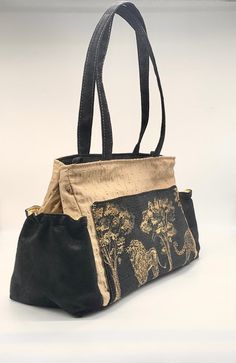 "Black and gold vegan handbag with lion tapestry. 2 handles to wear over the shoulder and a removable long handle to wear as a cross body. 13\" wide 9\" high 6 \" base . 2 inside pockets 1 outside pocket with sewn in magnet 2 side pockets to hold umbrella and water bottle." Elegant Rectangular Shoulder Bag With Pockets, Elegant Shoulder Satchel With Pockets, Elegant Tote Shoulder Bag With Pockets, Elegant Tote Bag With Pockets, Luxury Tote Shoulder Bag With Pockets, Luxury Shoulder Bag Tote With Pockets, Luxury Tote Bag With Pockets, Elegant Shoulder Bag With Pockets For Daily Use, Elegant Everyday Satchel With Pockets