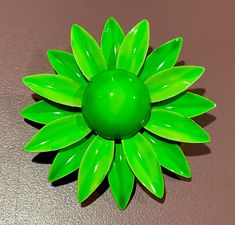 This beautiful boho retro brooch features a lovely green enamel flower design, perfect for adding a pop of color to any outfit. The item has a 1.5" diameter and was manufactured in the United States during the 1960s. The metal and enamel are in great shape, making it a wonderful vintage addition to any jewelry collection. The brooch is from the fashion jewelry department and is signed Original by Robert. . It is not customized and has not been altered in any way. The item is perfect for those wh Spring Green Brooch Gift, Green Spring Brooches As Gifts, Green Spring Brooches Perfect As A Gift, Green Spring Gift Brooches, Green Flower-shaped Enamel Brooch Pin, Green Flower Enamel Pin Brooch, Green Flower Shaped Enamel Pin Brooch, Mid-century Green Brooch As A Gift, Vintage Green Flower Brooches