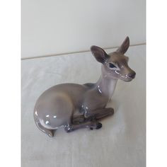 a glass deer figurine sitting on top of a white tablecloth covered floor