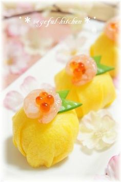 three small yellow lemons with flowers on them