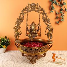 an ornate gold plated water fountain on a table