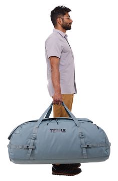 a man carrying a blue duffel bag