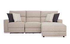 a beige sectional couch with pillows on it and two recliners facing each other