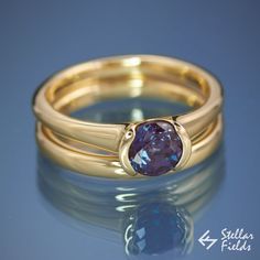 a gold ring with a blue stone on it's center and two bands around the band