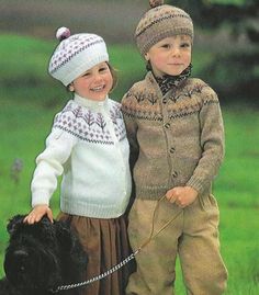 two young children standing next to each other with a dog on a leash in front of them