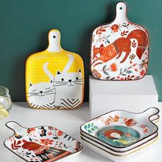 three ceramic dishes with cats painted on them