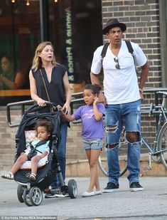 the family is walking down the street with their stroller