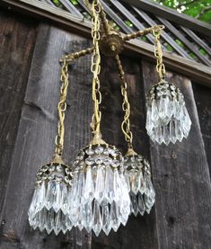 an old fashioned chandelier hanging from a wooden wall