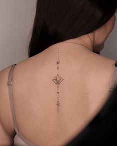 the back of a woman's shoulder with an arrow and flower tattoo on it